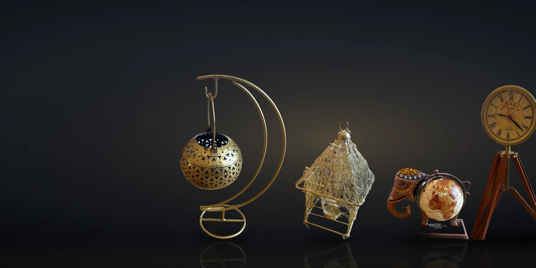 LEØSINN pieces — pierced brass candle holder, gold wire lantern, hand-painted elephant globe and station clock in warm light